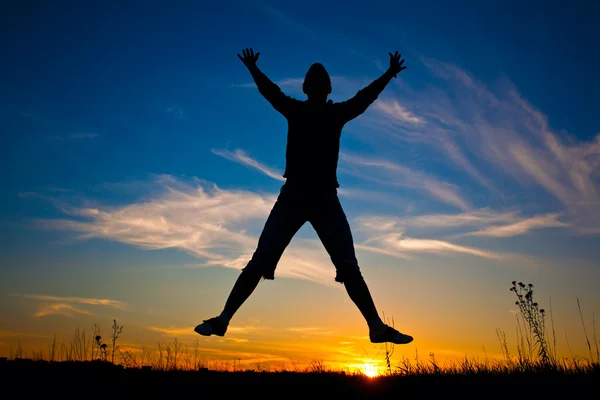 Mujer feliz saltando sobre el cielo azul puesta de sol —  Fotos de Stock