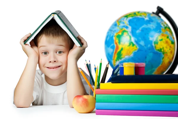 Un colegial gracioso con un libro en la cabeza. aislado — Foto de Stock