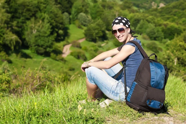 Girl is resting sitting on the grass in mountains — Stock Photo, Image