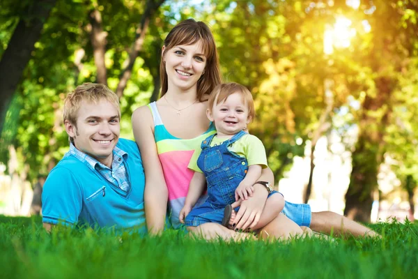 Familjen ligger på gräset — Stockfoto