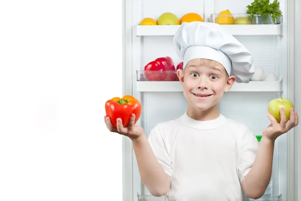 Bonito menino Chef perto da geladeira aberta — Fotografia de Stock