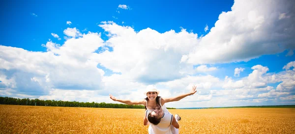 Happy couple in the field of wheat with blue sky — Stock Photo, Image