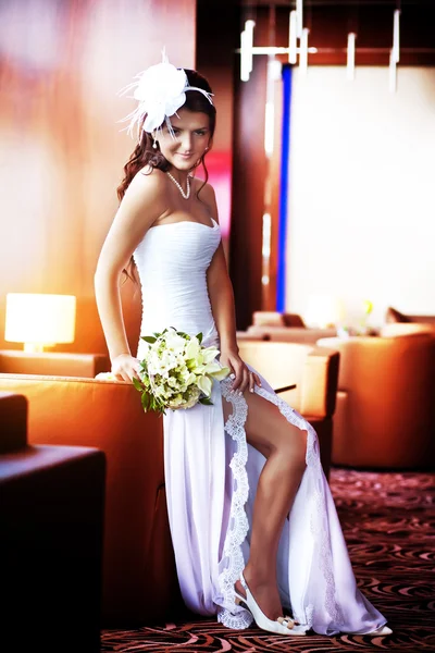 Glückliche Braut sitzt in einem hellen Raum — Stockfoto