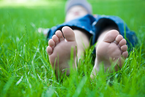 Children's feet on grass. picnic in spring park