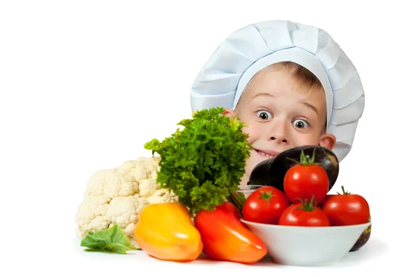 Cute chef boy is hiding behind a vegetables. isolated — Stock Photo, Image