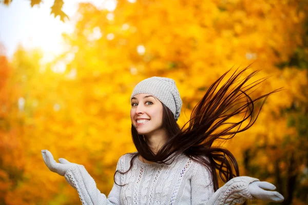Feliz chica alegre sobre un fondo de árboles de otoño —  Fotos de Stock