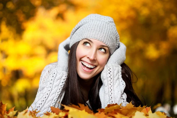 Happyl mujer está acostado en un amarillo otoño hojas — Foto de Stock