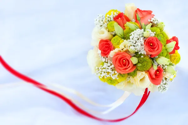 Bouquet of rad roses on the white wedding dress — Stock Photo, Image