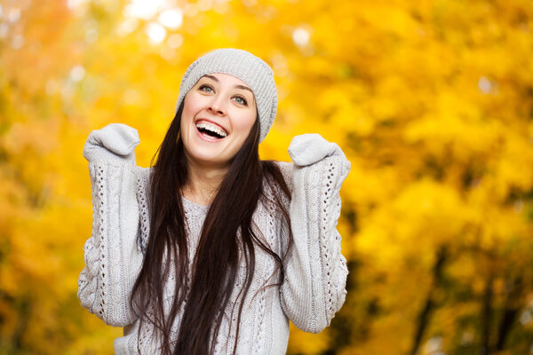 Happy cheerful woman on a background of autumn trees
