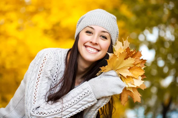 Feliz mujer alegre sobre el fondo de los árboles otoñales —  Fotos de Stock