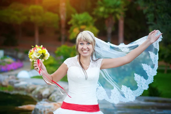 Смешная невеста в белом платье в парке — стоковое фото
