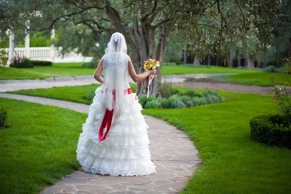 Невеста гуляет по зеленому парку — стоковое фото