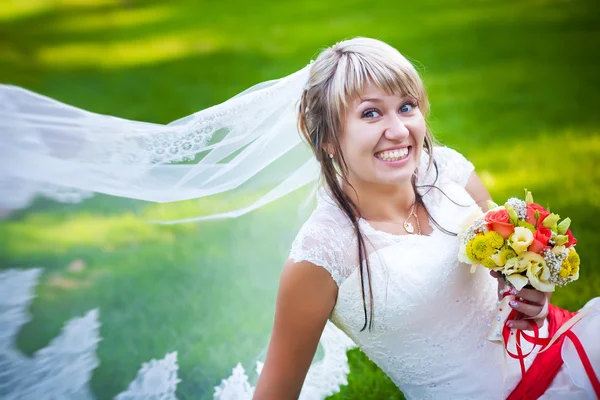 Novia feliz en vestido blanco cerca de la hierba verde — Foto de Stock