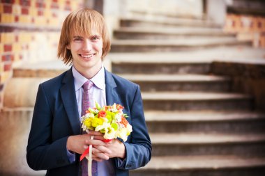 bir buket çiçek ile damadın gelini için bekliyor