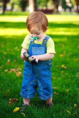 küçük bebek çantası yeşil park ile oynuyor