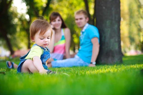 Baby met ouders in een mooie zomerse park — Stockfoto