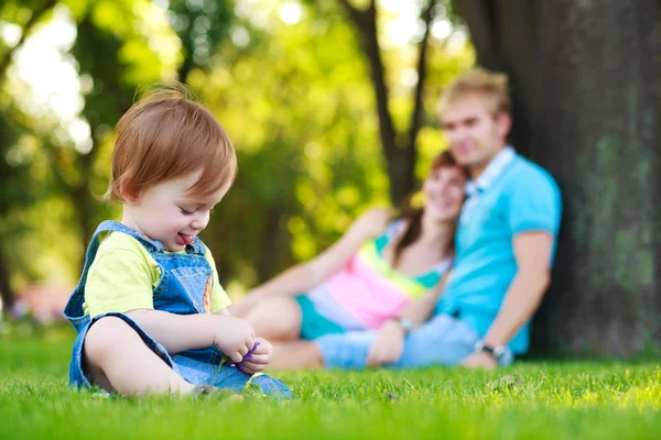 Bambino che gioca con i genitori in un bellissimo parco estivo — Foto Stock