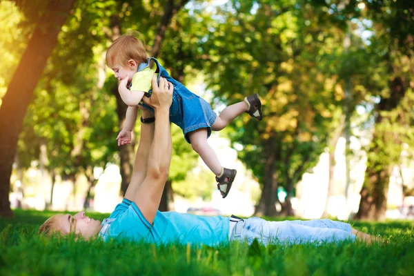 Papai feliz com bebê em um parque de verão verde — Fotografia de Stock