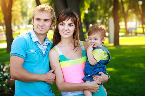 Portret bebê com os pais em um belo parque de verão — Fotografia de Stock