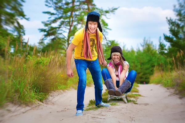 Funny couplel are sledding at summer — Stock Photo, Image