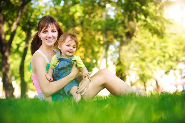 Funny baby with mom in park Stock Picture