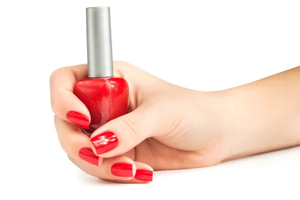 Hand met rode nagellak fles geïsoleerd — Stockfoto