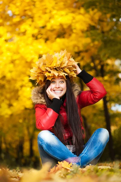 Mujer bonita en una corona de hojas de otoño — Foto de Stock