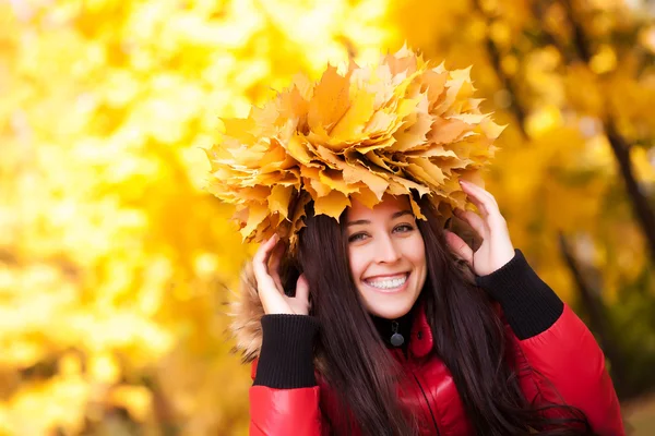 Roztomilá dívka v věnec žluté podzimní listy — Stock fotografie