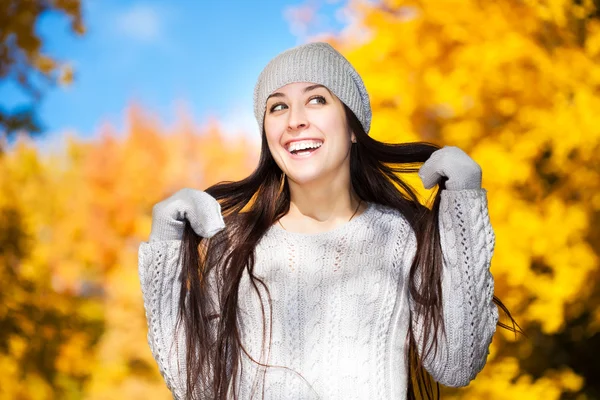 Linda chica alegre sobre un fondo de árboles de otoño —  Fotos de Stock