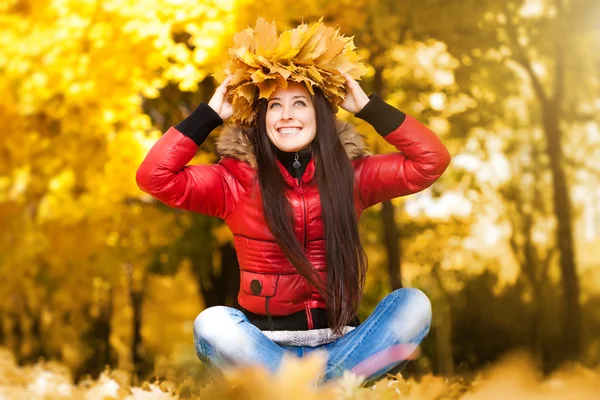 Fröhliche, fröhliche Frau in einem Kranz aus Herbstblättern — Stockfoto