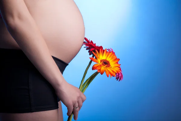 美丽的孕妇用鲜花 — 图库照片