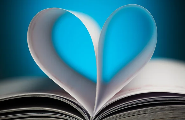 Signo de corazón con páginas de libros sobre el azul — Foto de Stock