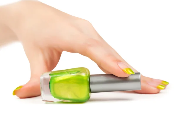 Main de femme avec une bouteille de vernis à ongles vert — Photo