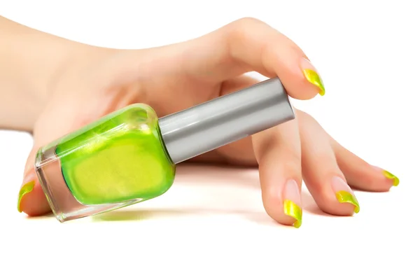 Mano de mujer con una botella de esmalte de uñas verde — Foto de Stock