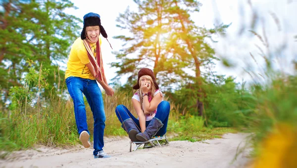 Crazy boy and girl are sledding at summer — Stock Photo, Image