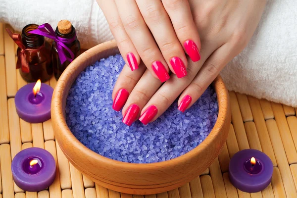 Manos femeninas con velas aromáticas y toalla. Spa — Foto de Stock