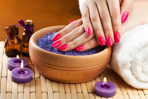 Manos femeninas con velas aromáticas y toalla. Spa — Foto de Stock