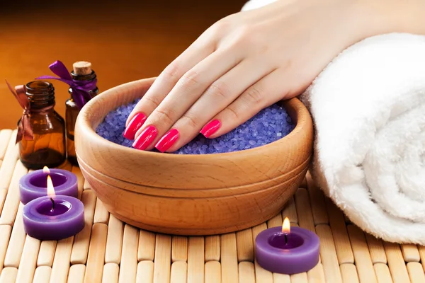 Mani femminili con candele aromatiche e asciugamano. Spa — Foto Stock