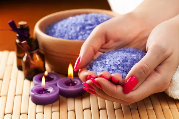 Manos femeninas con velas aromáticas y toalla. Spa — Foto de Stock