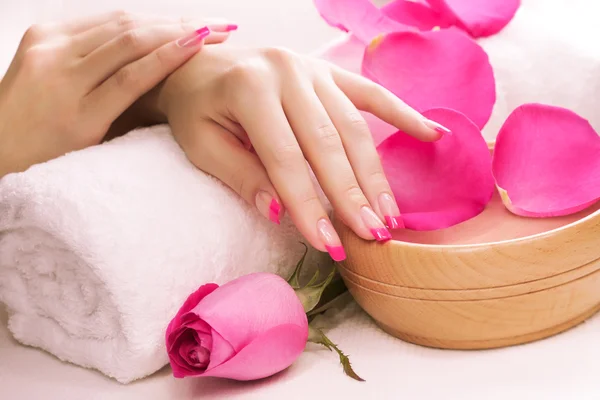 Hermosa manicura con pétalos de rosa fragantes y toalla. Spa —  Fotos de Stock