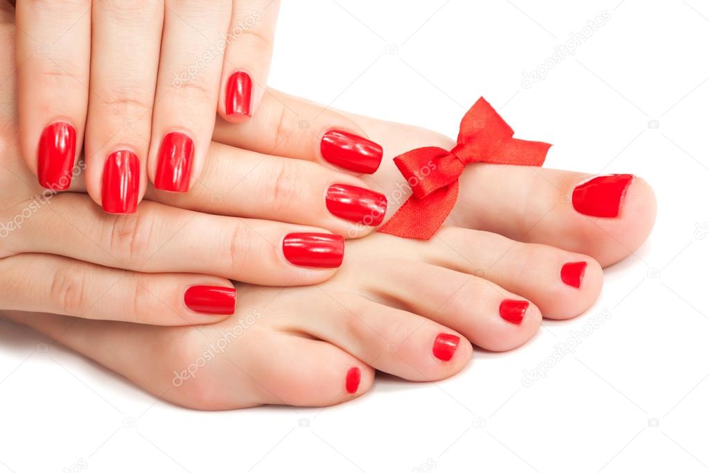Red manicure and pedicure with a bow