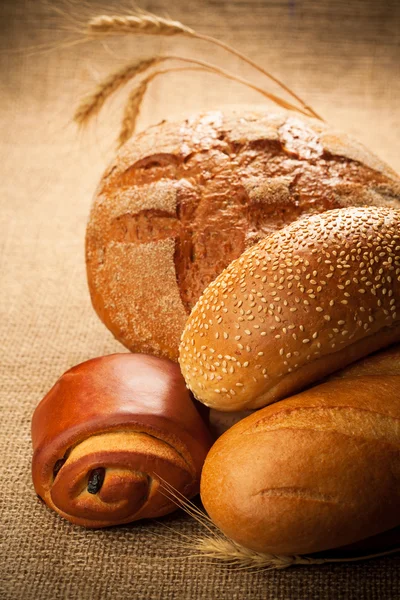 Assortiment van vers gebakken brood op jute — Stockfoto