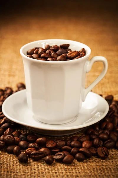 Grains de café torréfiés dans une tasse — Photo
