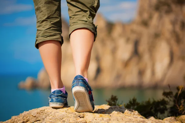 Turism. kvinnliga fötter i sneakers — Stockfoto