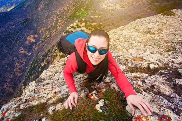 Woman tourist looks for way from the rocks top — Stock Photo, Image