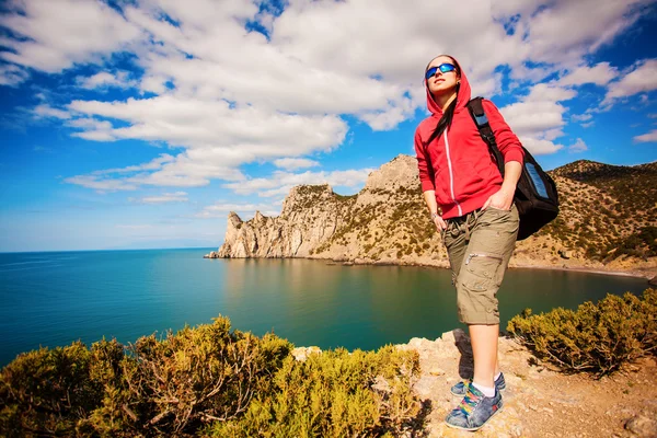 Woman tourist is looking for way from the rocks top — Stock Photo, Image