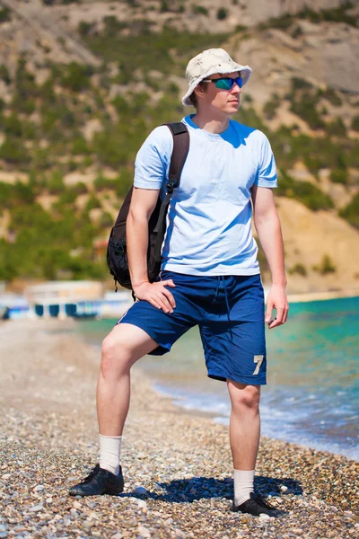 Mannen i panama hatt promenerar på stranden — Stockfoto