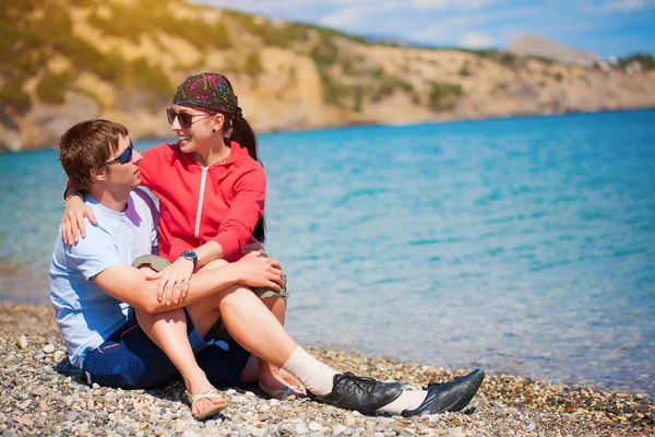 Gelukkige paar zijn sittting op het strand — Stockfoto