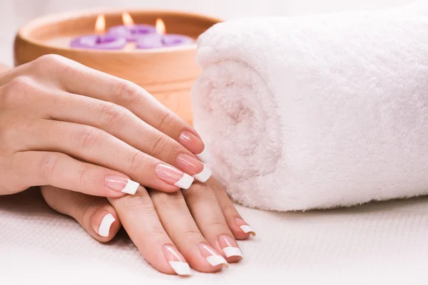 Female hands with aromatic candles and towel. Spa — Stock Photo, Image