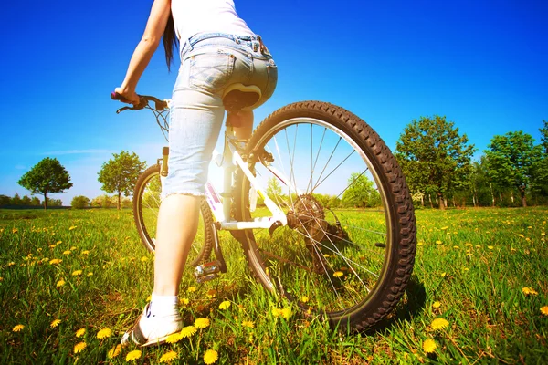 Frau im grünen Park auf dem Fahrrad — Stockfoto